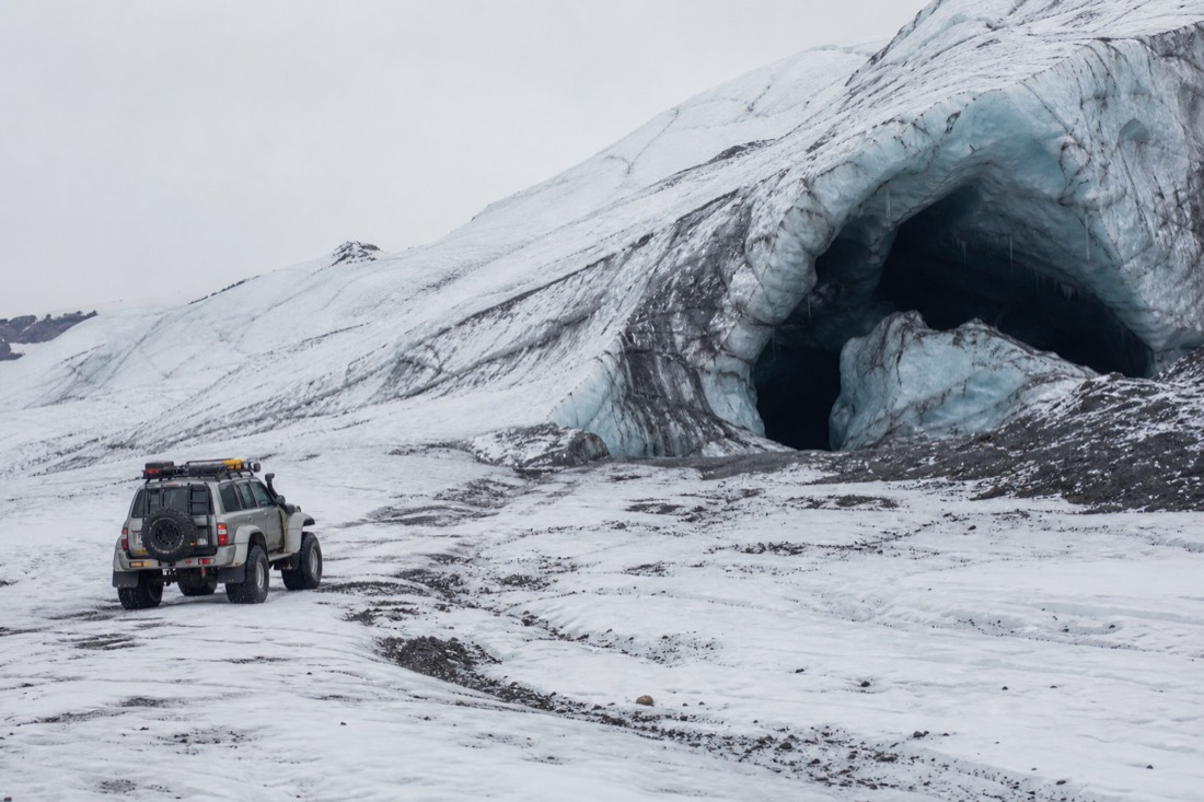 Modified super-jeep crossing Vatnajökull glacier terrain toward an ice cave entrance in Iceland